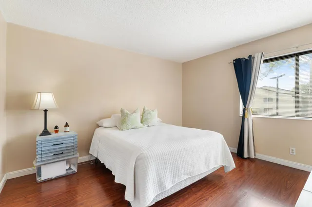 a bedroom with a bed window and wooden floor
