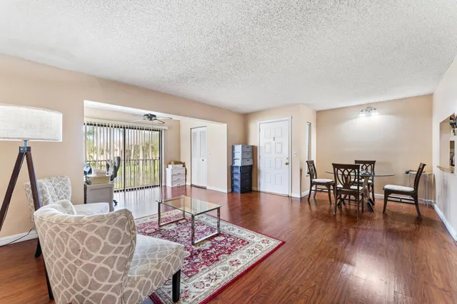 a living room with furniture a window and wooden floor