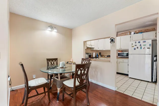 a kitchen with a dining table chairs and refrigerator