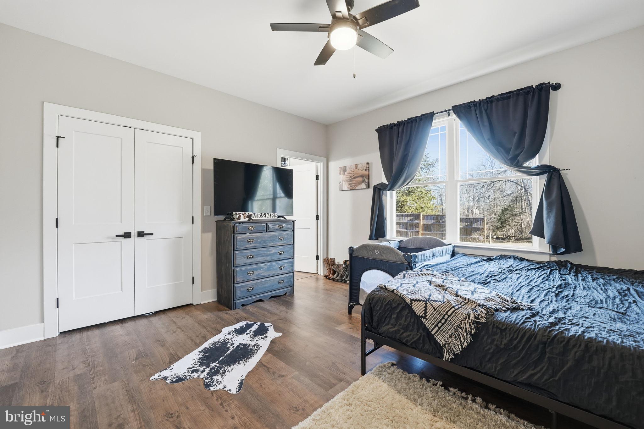 11183 Drogheda Mountain Road Culpeper, VA 22701 - Photo 15 of 60 a bedroom with a bed closet and flat tv screen