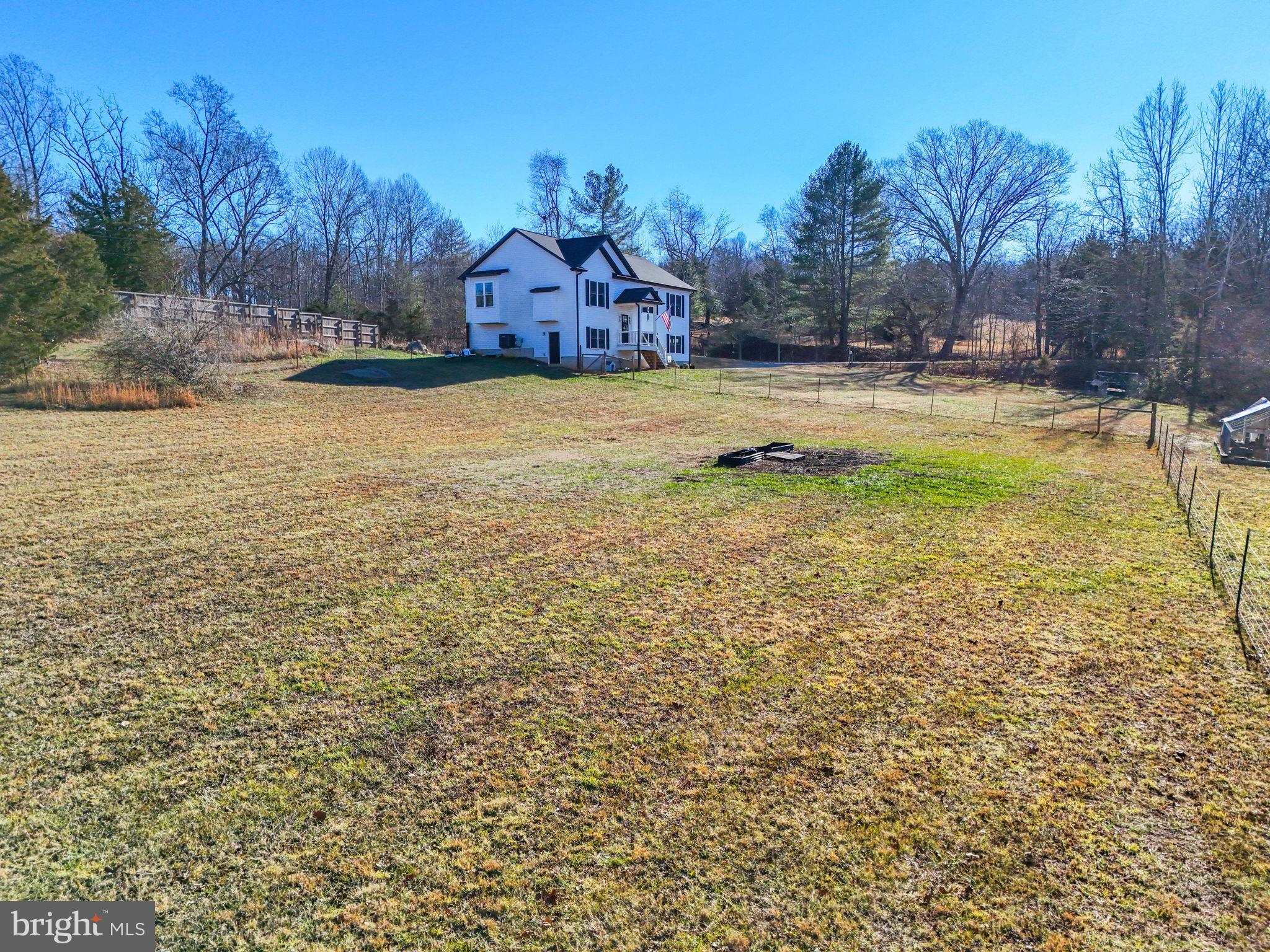 11183 Drogheda Mountain Road Culpeper, VA 22701 - Photo 36 of 60 a view of a swimming pool and a yard in front of the house