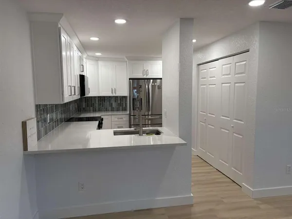a large white kitchen with a sink and dishwasher