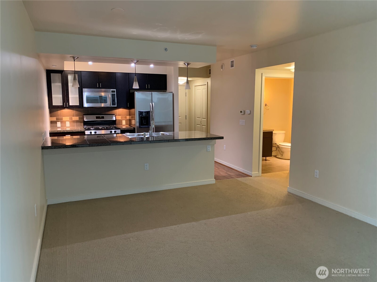 819 Virginia Street, Unit 2808 Seattle, WA 98101 - Photo 8 of 34 a view of a kitchen with kitchen island a sink wooden floor and counter top space