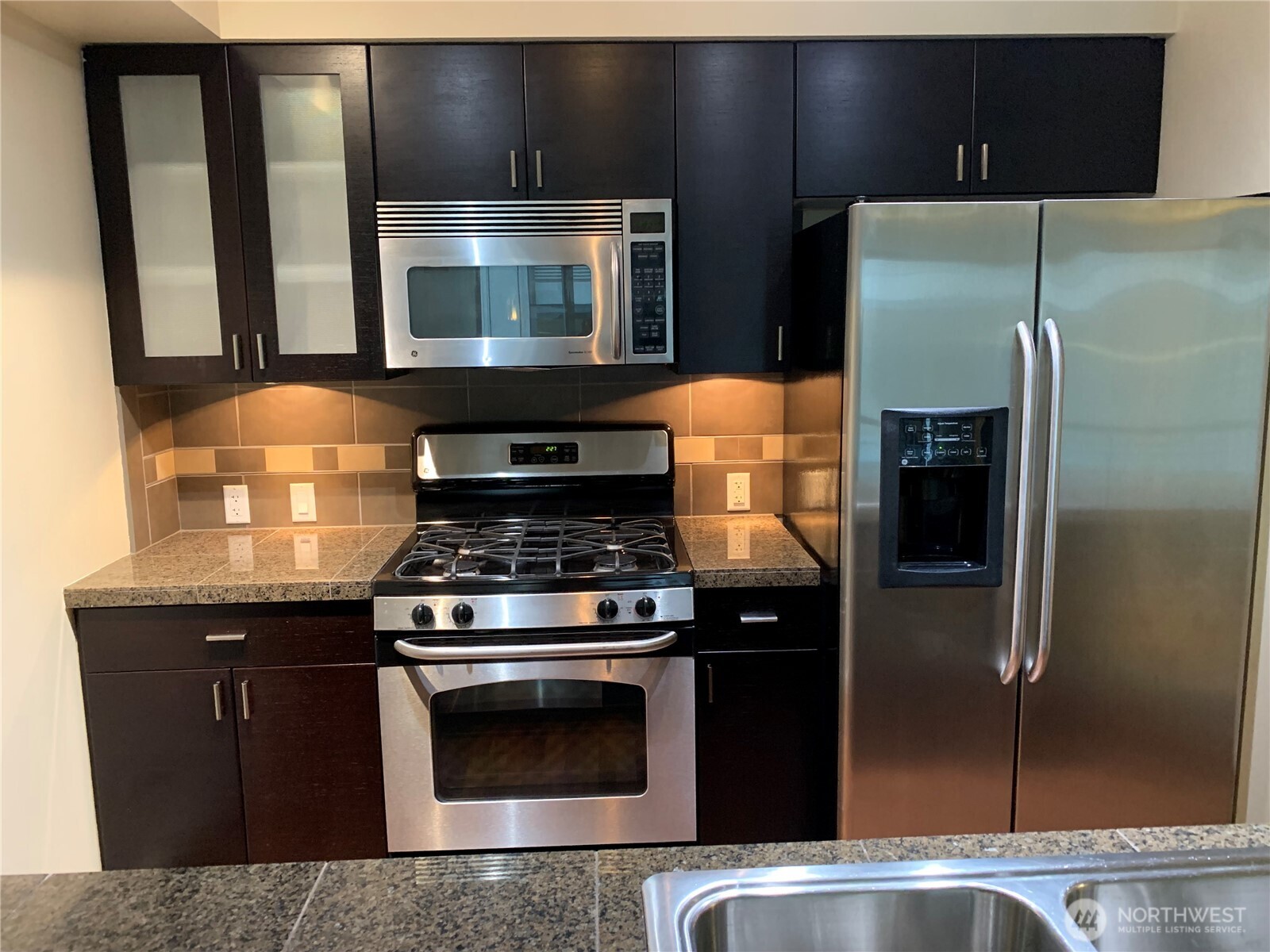 819 Virginia Street, Unit 2808 Seattle, WA 98101 - Photo 9 of 34 a kitchen with granite countertop a stove and a microwave
