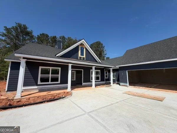 a front view of a house with large windows and a table and chairs
