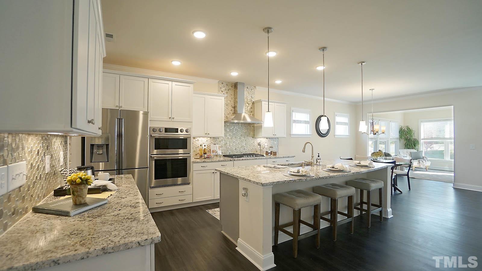 620 Trocha Drive Cary, NC 27513 - Photo 12 of 44 a kitchen with stainless steel appliances granite countertop a stove top oven a sink refrigerator and cabinets