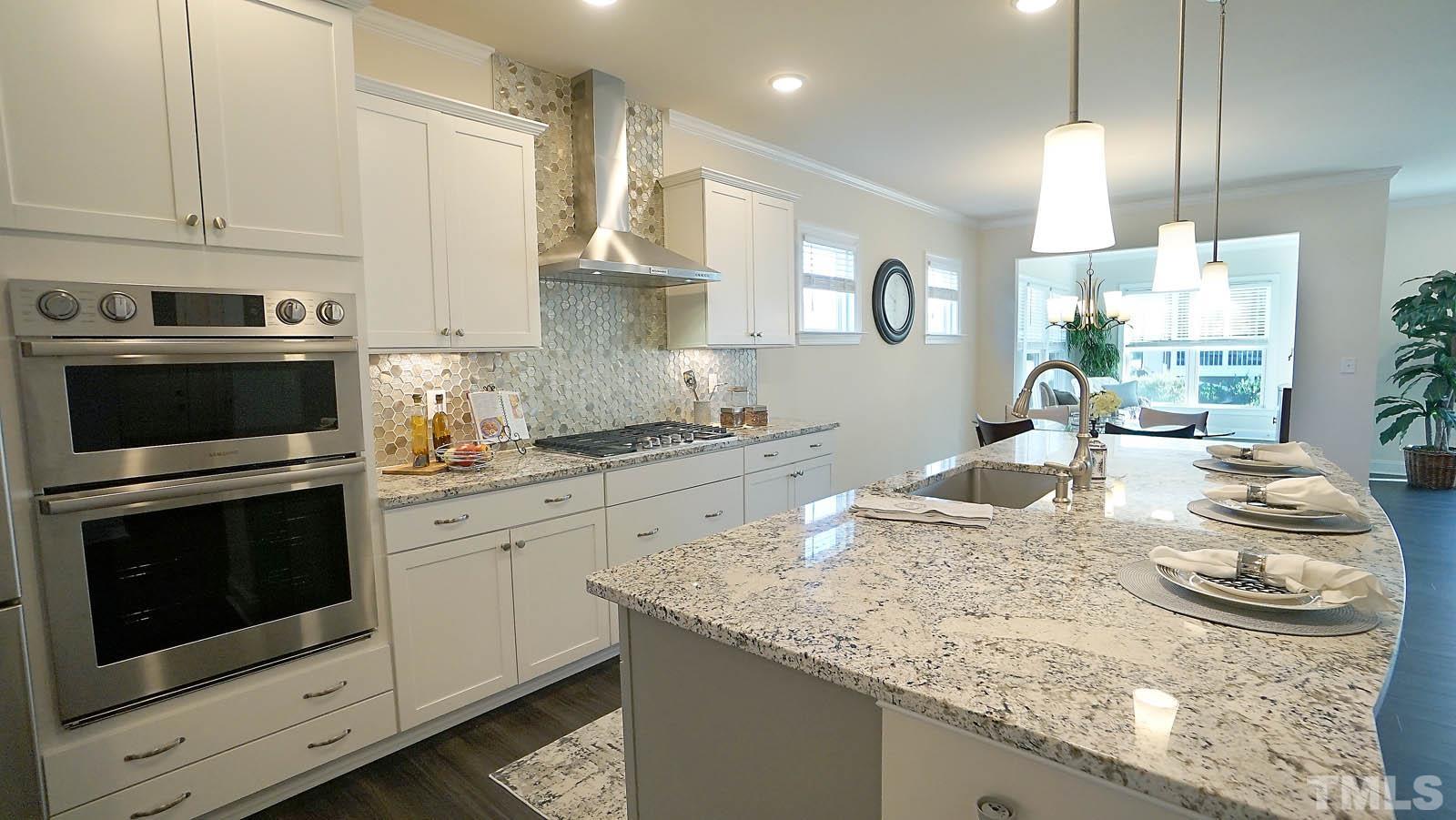 620 Trocha Drive Cary, NC 27513 - Photo 14 of 44 a kitchen with kitchen island granite countertop a sink a stove and cabinets
