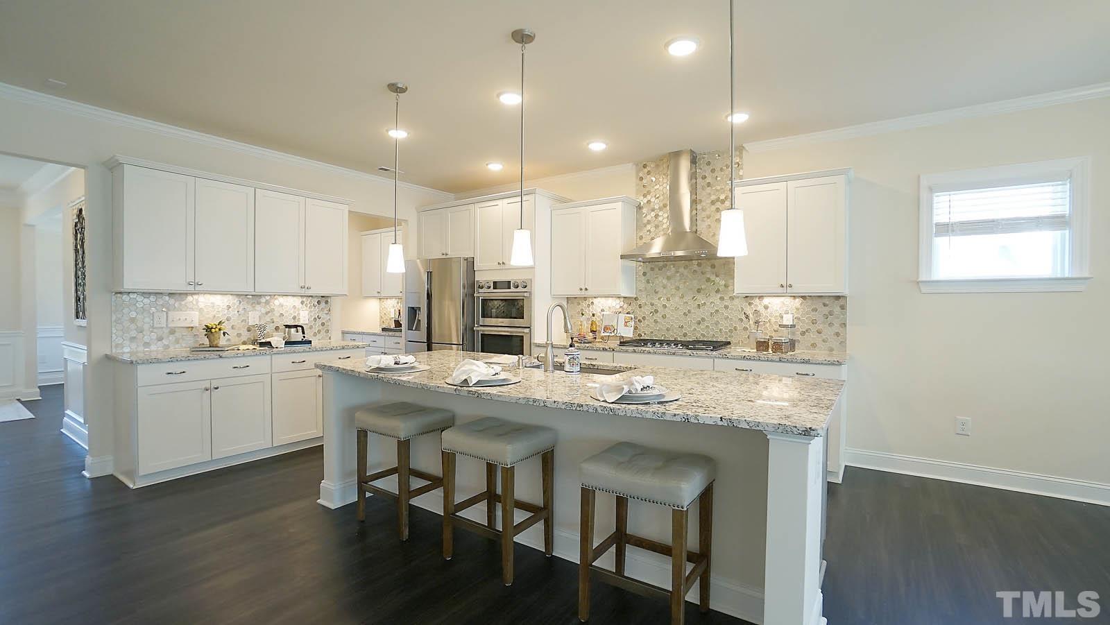 620 Trocha Drive Cary, NC 27513 - Photo 15 of 44 a kitchen with kitchen island granite countertop a sink and cabinets