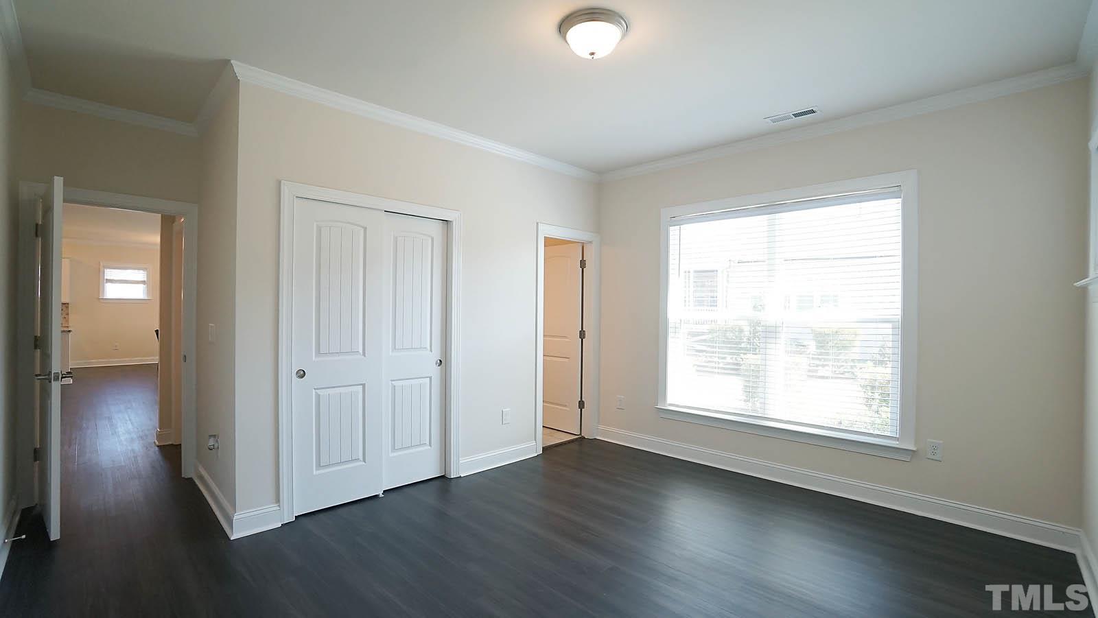 620 Trocha Drive Cary, NC 27513 - Photo 26 of 44 an empty room with wooden floor cabinet and windows