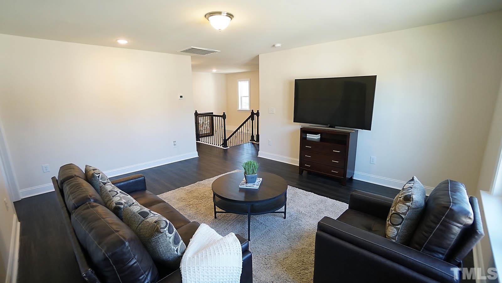 620 Trocha Drive Cary, NC 27513 - Photo 31 of 44 a living room with furniture a flat screen tv and a window