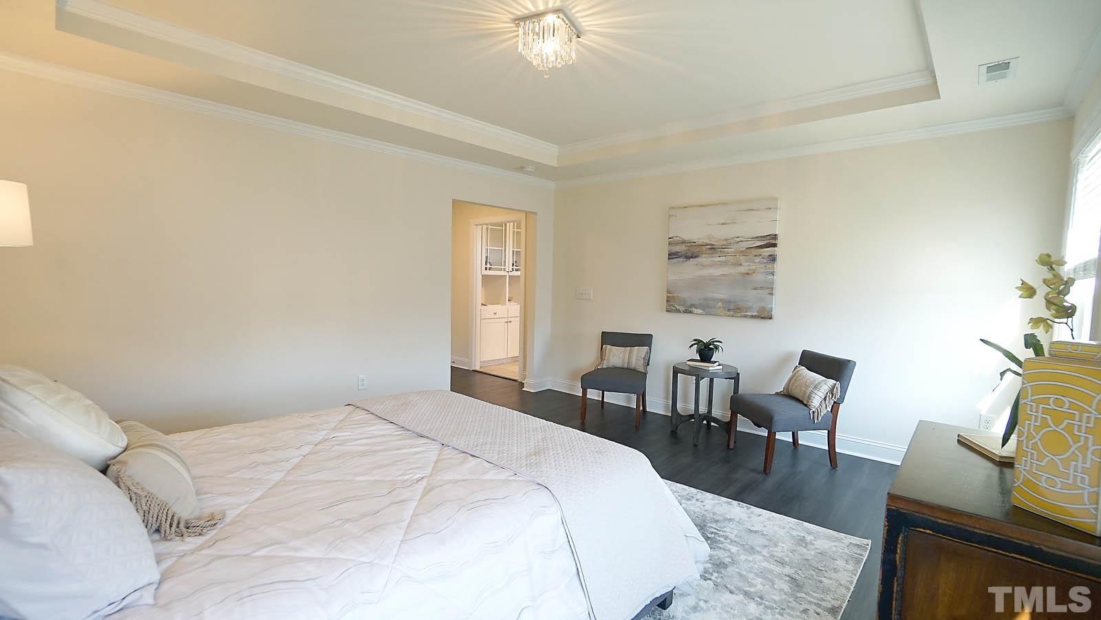 620 Trocha Drive Cary, NC 27513 - Photo 33 of 44 a spacious bedroom with a bed a couch and a potted plant on the dresser