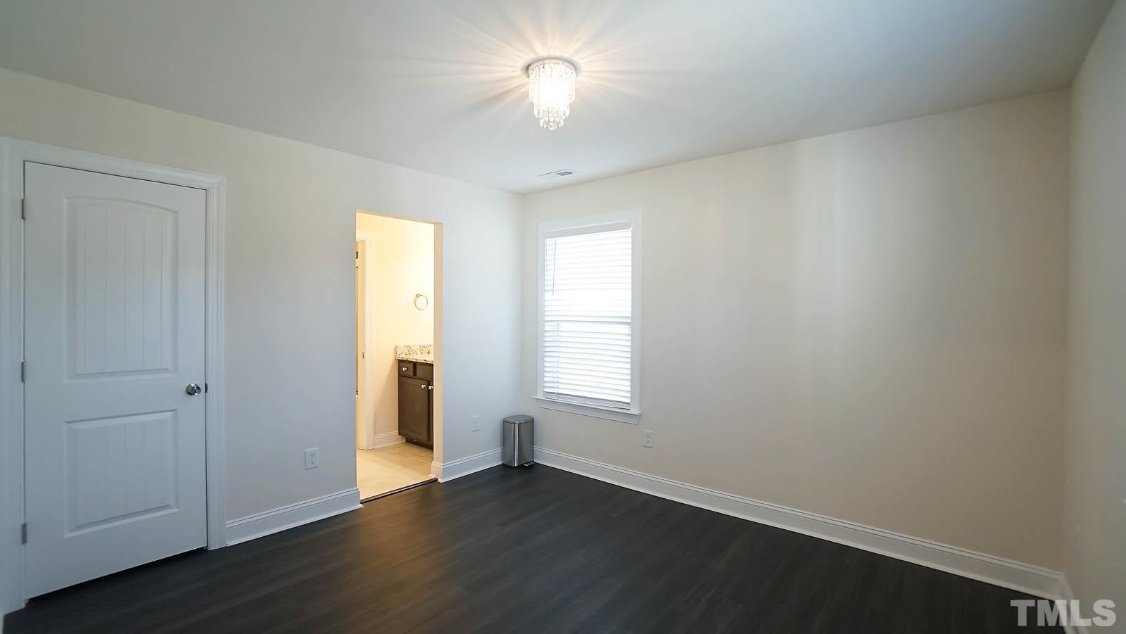 620 Trocha Drive Cary, NC 27513 - Photo 38 of 44 an empty room with wooden floor and windows