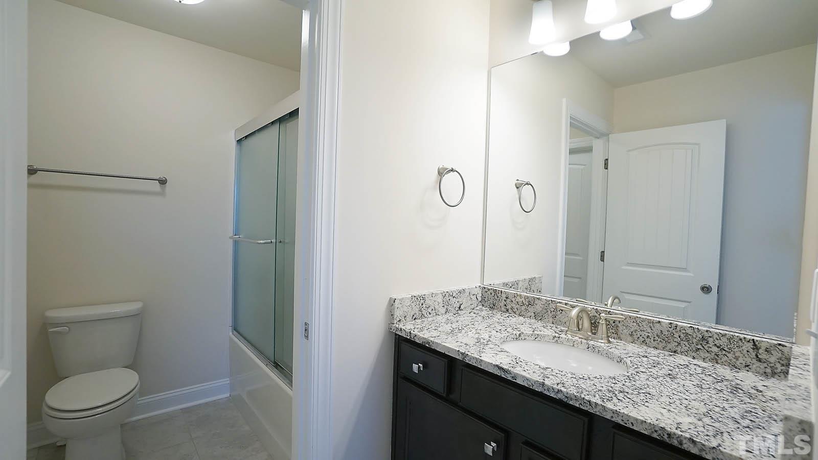 620 Trocha Drive Cary, NC 27513 - Photo 39 of 44 a bathroom with a granite countertop sink toilet and shower