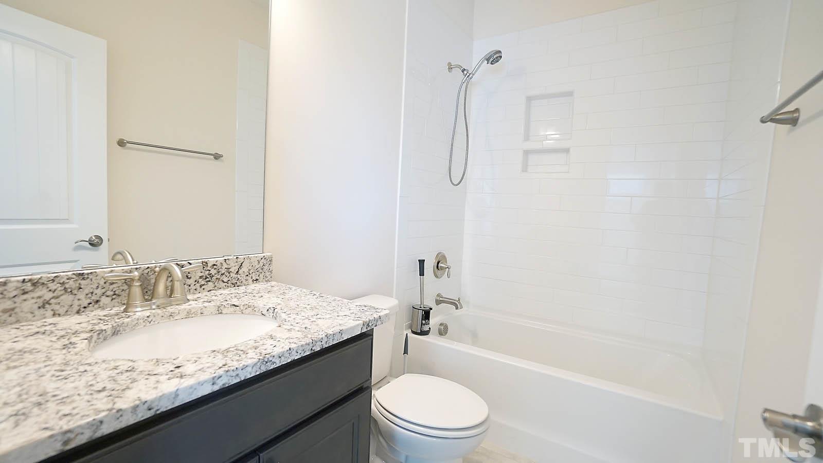 620 Trocha Drive Cary, NC 27513 - Photo 41 of 44 a bathroom with a granite countertop sink a toilet and shower