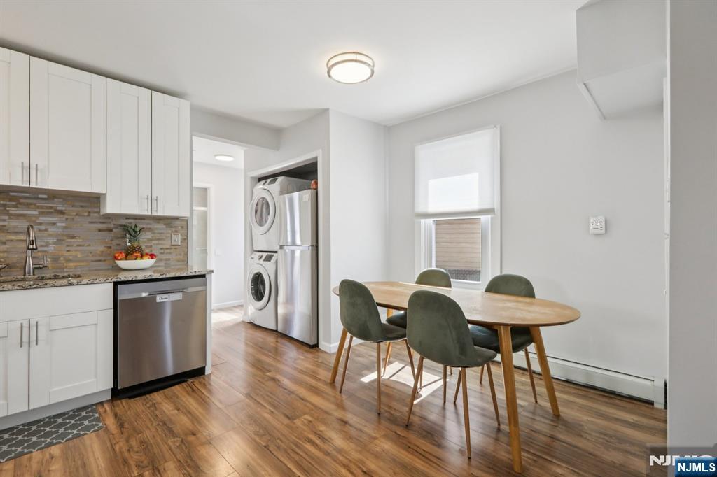 22 Treptow Street Little Ferry, NJ 07643 - Photo 11 of 44 a kitchen with stainless steel appliances granite countertop a stove a refrigerator a sink a dining table and chairs with wooden floor