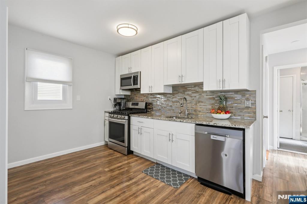 22 Treptow Street Little Ferry, NJ 07643 - Photo 14 of 44 a kitchen with stainless steel appliances granite countertop a stove a sink and white cabinets