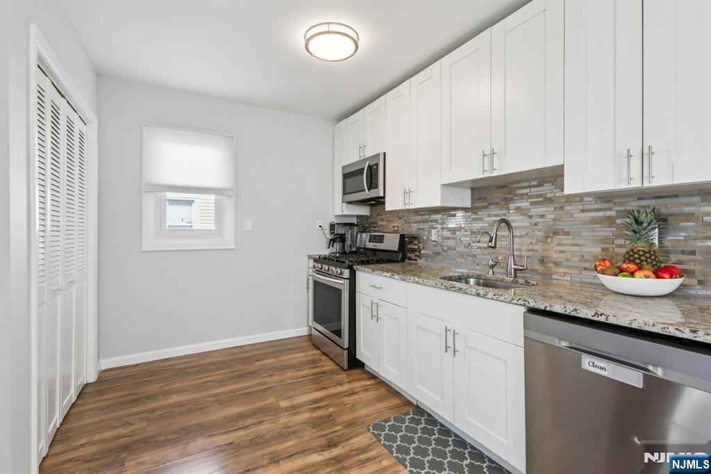 22 Treptow Street Little Ferry, NJ 07643 - Photo 15 of 44 a kitchen with granite countertop a sink stainless steel appliances and white cabinets