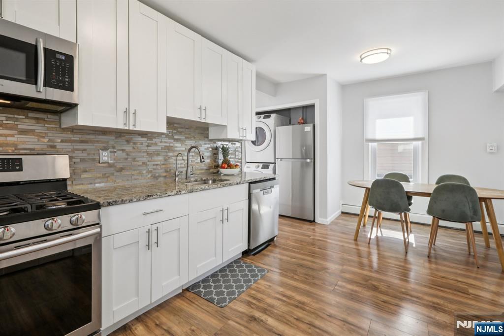 22 Treptow Street Little Ferry, NJ 07643 - Photo 16 of 44 a kitchen with granite countertop a stove a sink a refrigerator and chairs