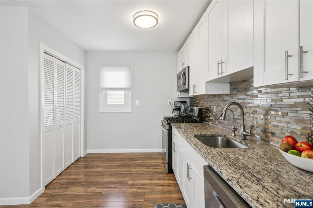 22 Treptow Street Little Ferry, NJ 07643 - Photo 17 of 44 a kitchen with granite countertop a sink a stove and cabinets
