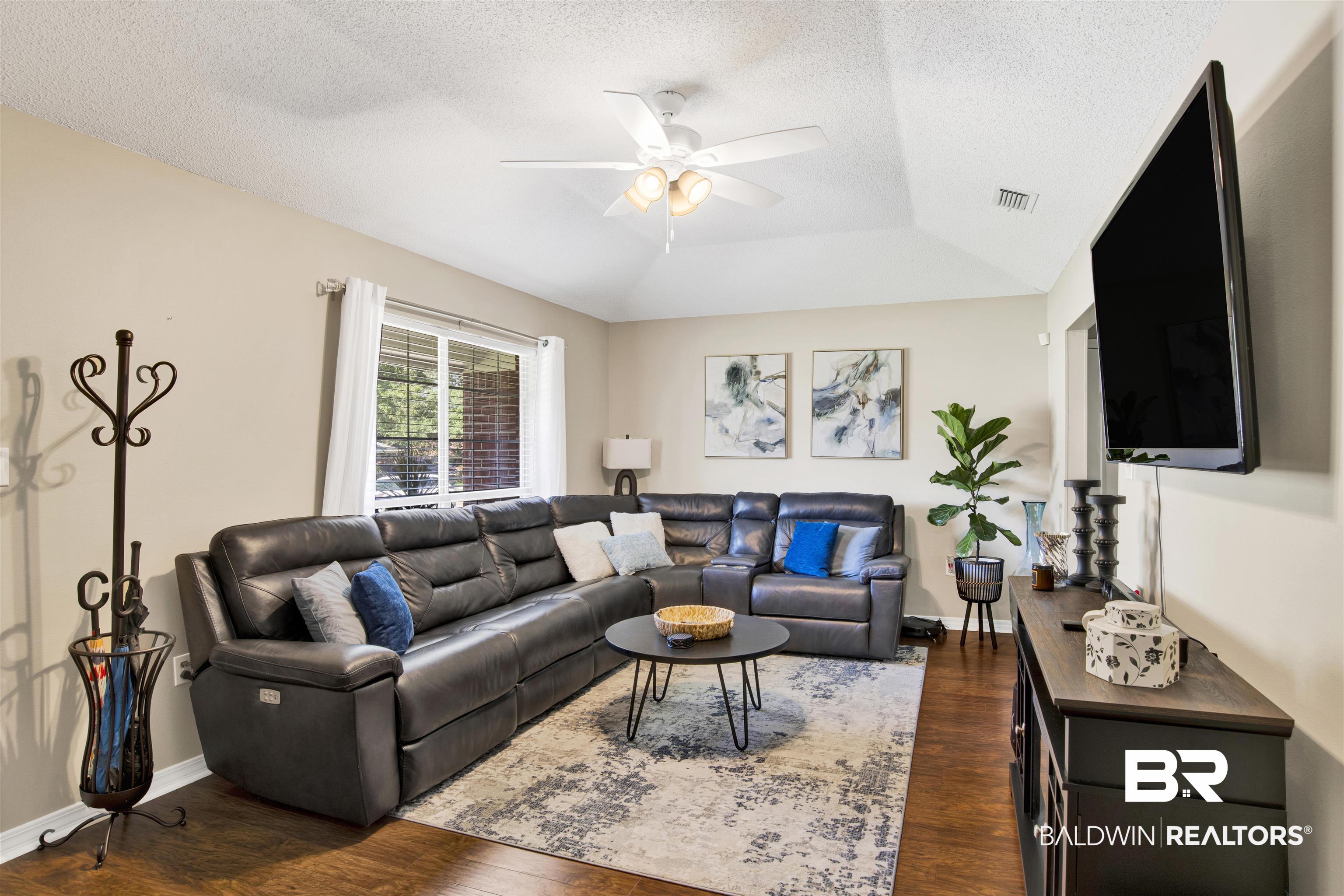 6281 Woodside Drive Theodore, AL 36582 - Photo 3 of 17 Living room featuring a textured ceiling, dark wood finished floors, vaulted ceiling, and ceiling fan
