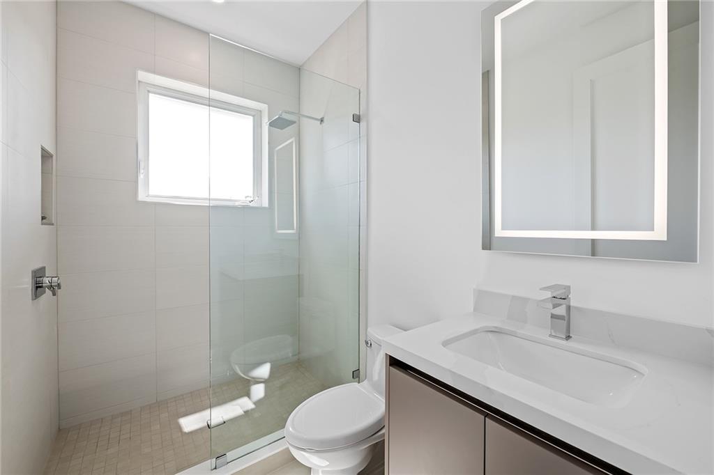 3204 Dover Road Pompano Beach, FL 33062 - Photo 58 of 73 a bathroom with a toilet a sink a mirror and a shower
