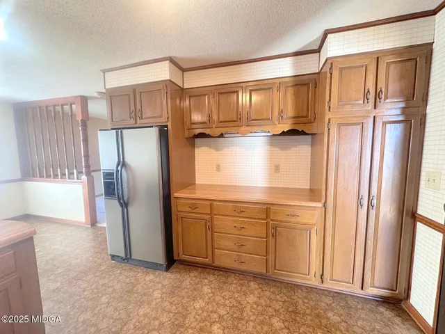a kitchen with stainless steel appliances a refrigerator and a cabinets