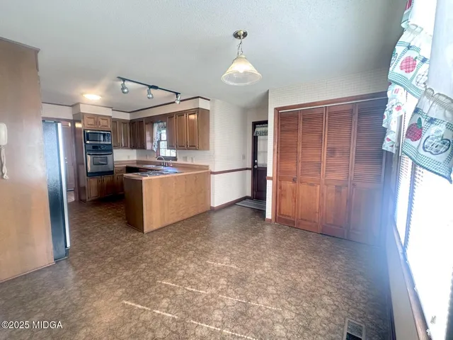 a kitchen with stainless steel appliances granite countertop a refrigerator and a sink