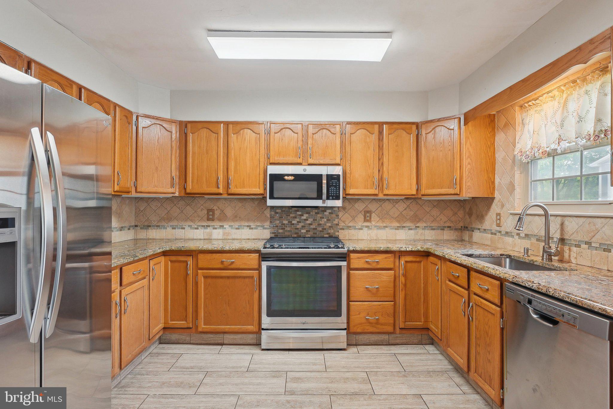 317 Clems Run Mullica Hill, NJ 08062 - Photo 11 of 33 a kitchen with stainless steel appliances granite countertop a stove sink and cabinets
