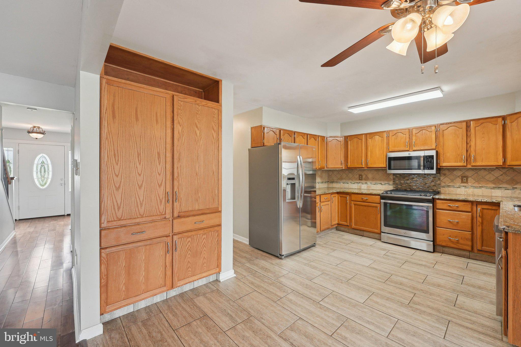 317 Clems Run Mullica Hill, NJ 08062 - Photo 10 of 33 a kitchen with stainless steel appliances granite countertop a refrigerator a sink dishwasher a stove with wooden cabinets and floor