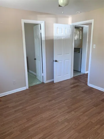 an empty room with wooden floor and mirror
