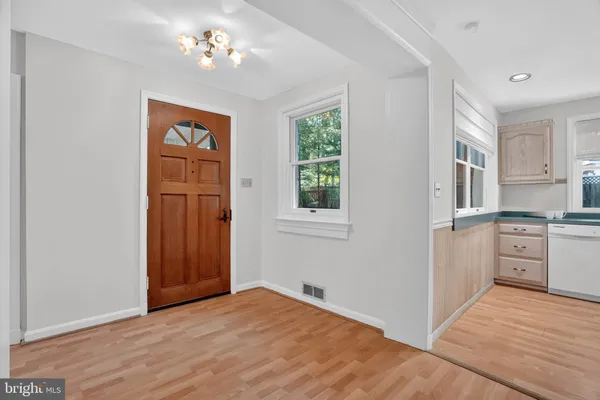 a view of a kitchen with a sink and dishwasher with wooden floor