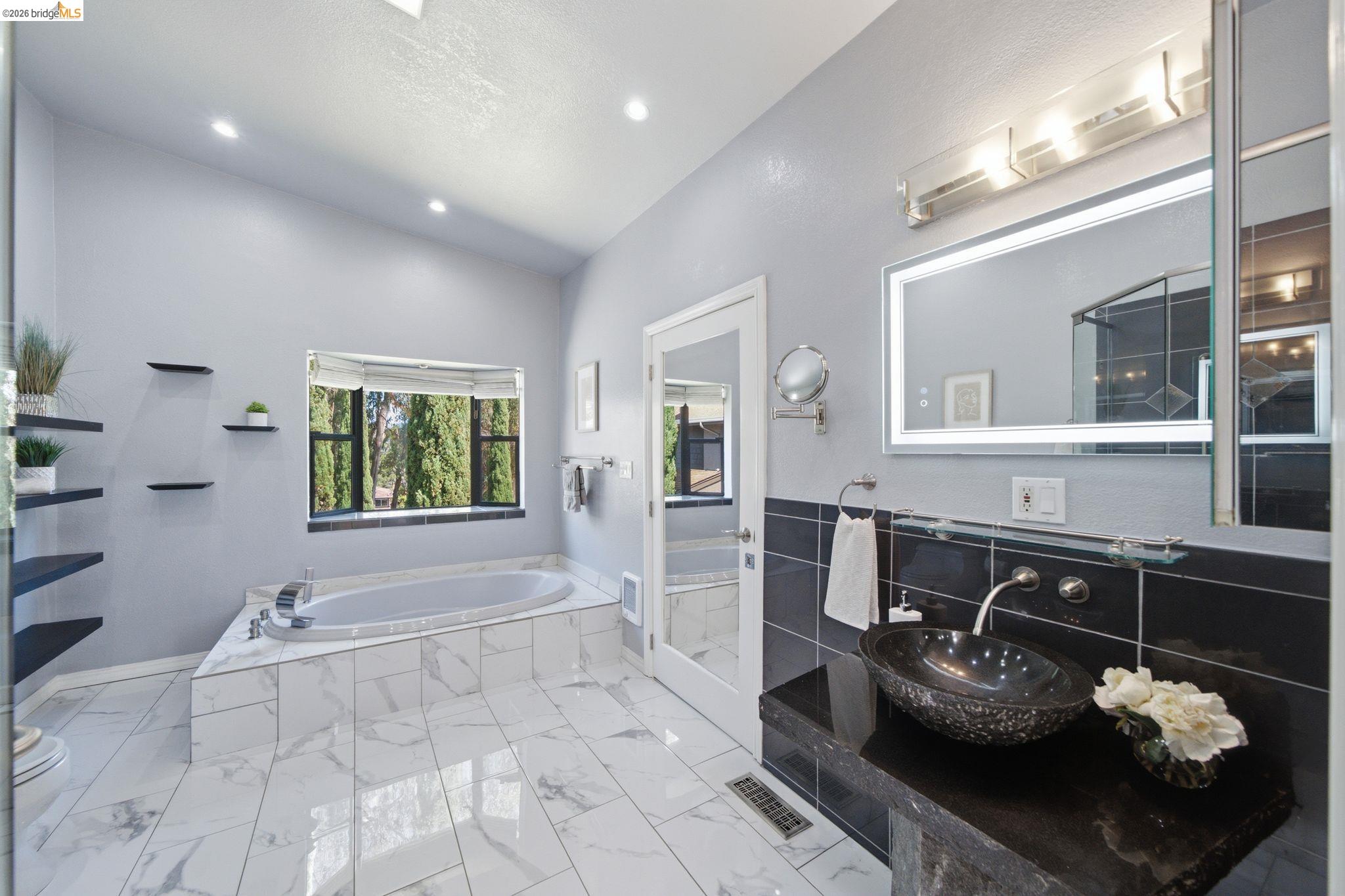 11133 Golf Links Road Oakland, CA 94605 - Photo 31 of 57 Spacious bathroom featuring a built-in soaking tub, large window, and recessed lighting