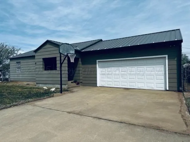 a view of house with garage and small yard