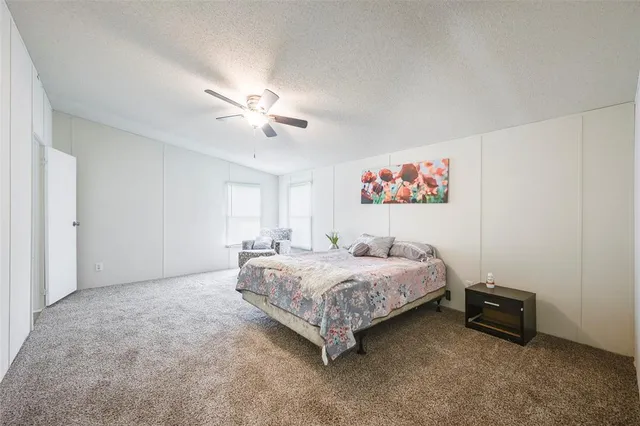 a spacious bedroom with a bed and a chandelier