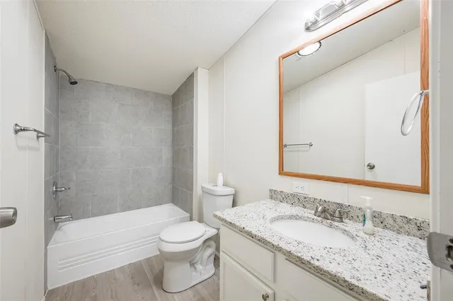 a bathroom with a granite countertop sink toilet and shower