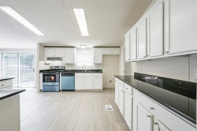 a kitchen with stainless steel appliances granite countertop a stove sink and cabinets