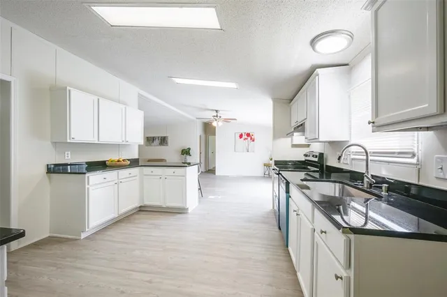 a kitchen with a sink stove top oven and cabinets