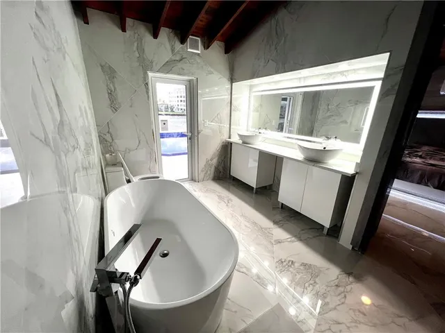 a bathroom with a bathtub sink and mirror