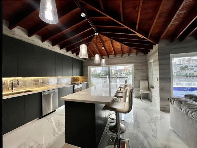 a kitchen with a sink a table and chairs in it