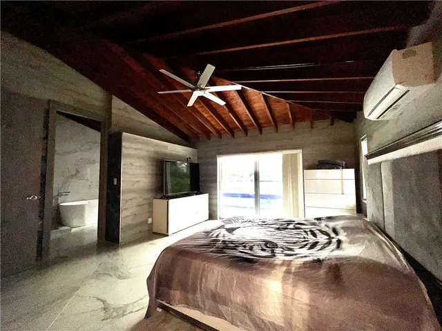 a bed sitting in a bedroom next to a window