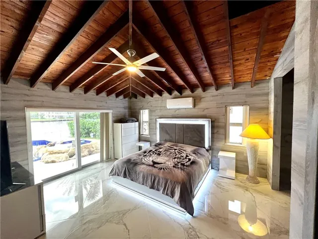 a bedroom with a bed a couch and a chandelier