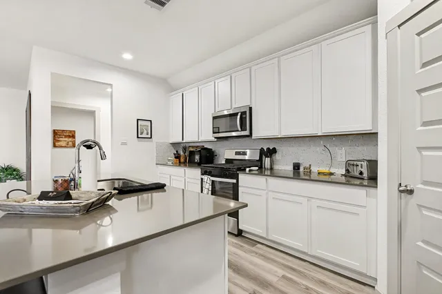 a kitchen with cabinets a sink and appliances