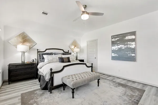 a bedroom with a bed lamp and a dresser