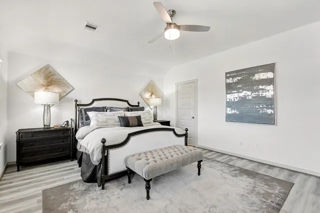 a bedroom with a bed lamp and a dresser