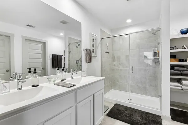 a bathroom with double sink and a shower