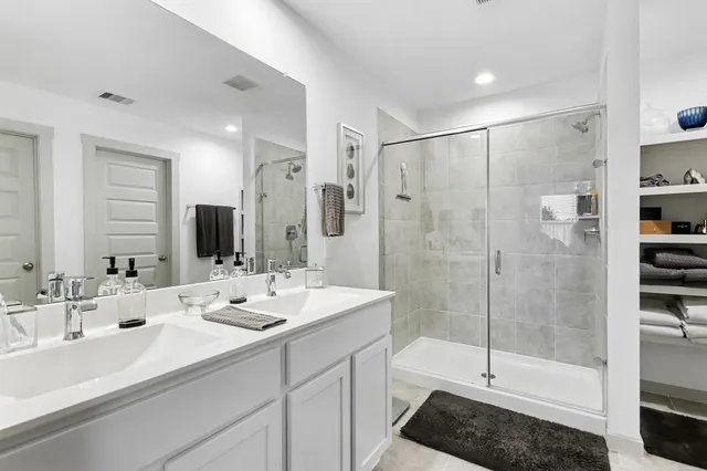 a bathroom with double sink and a shower