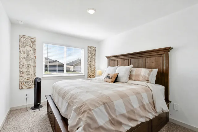 a bedroom with a bed and a window