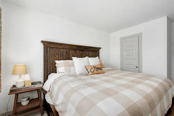 a bedroom with a bed and a lamp on table