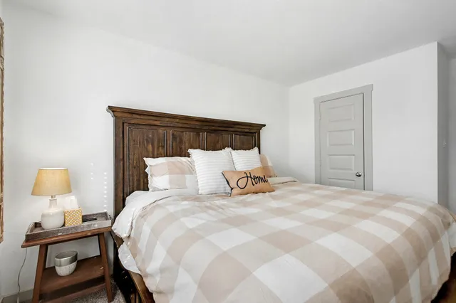 a bedroom with a bed and a lamp on table