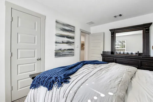 a bedroom with a bed and a large mirror